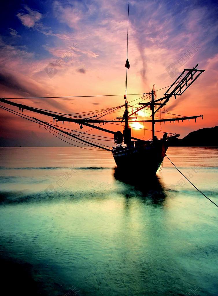 彩色光影炫彩彩云下的海面上的船只自然光影背景图片