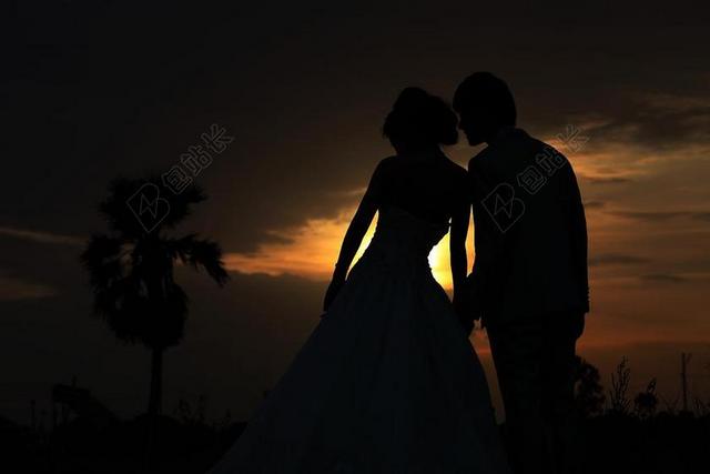 黄黑光影唯美夕阳下的亲吻的新人婚礼摄影光影背景图片