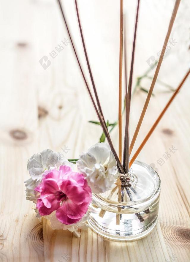 粉色香味芳香疗法气味香水治疗玻璃杯散发清新白色花朵背景图片