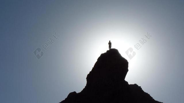 黑蓝运动极限阳光下山顶上的人登山冒险运动自然背景图片