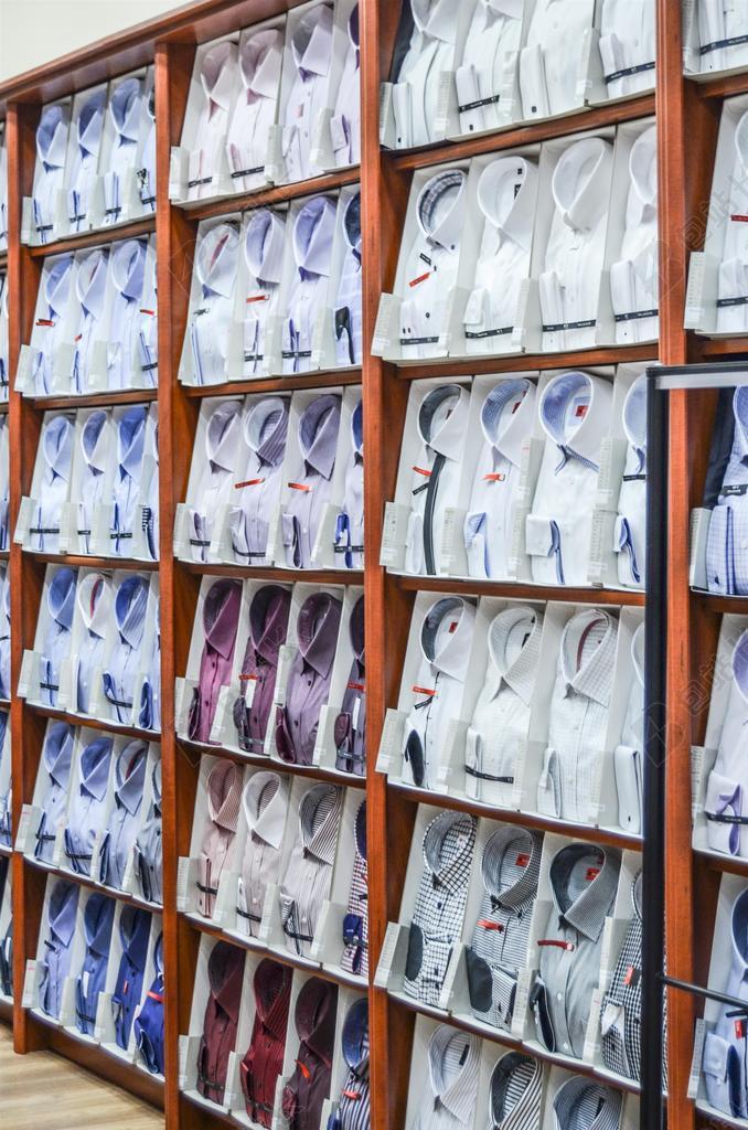 白黄服装丰富架子上的不同衬衫展示销售服装背景图片