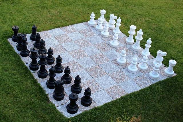 彩色娱乐草地上的黑白棋子下棋博弈背景图片