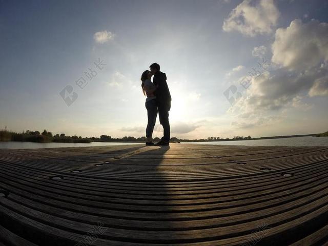 灰蓝人物浪漫蓝天下站着亲吻的男女情侣旅游自然背景图片