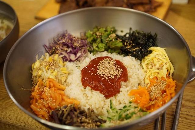 韩国特色石锅拌饭中菜品丰富在碗中摆放背景图片
