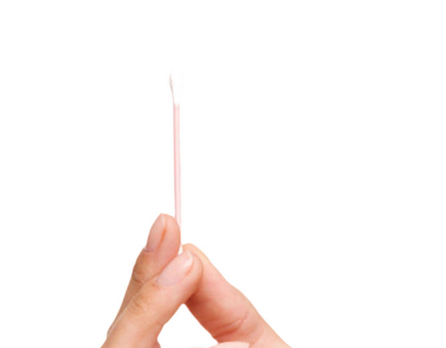 手拿着粉红色棒子的棉签清洁用品