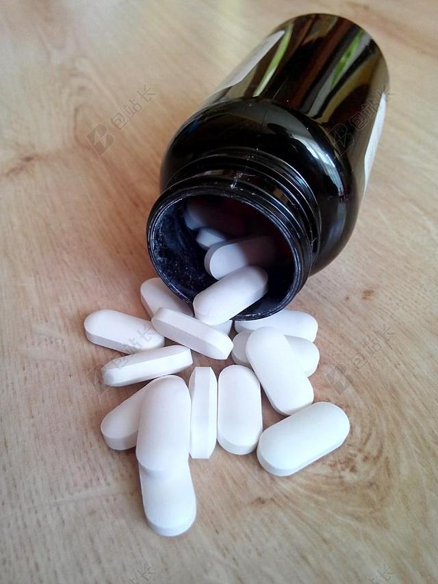 白色医疗特写白色的药丸和药瓶背景图片