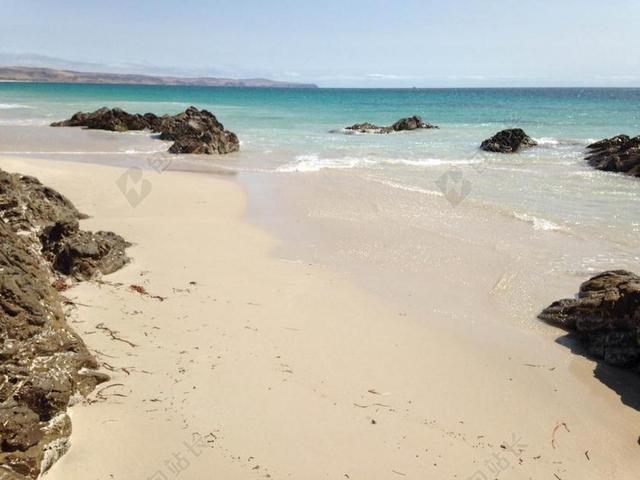 蓝白沙滩大气礁石海水海边背景图片