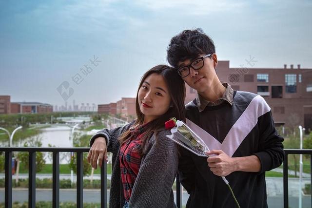 栏杆边微笑的情侣背景图片
