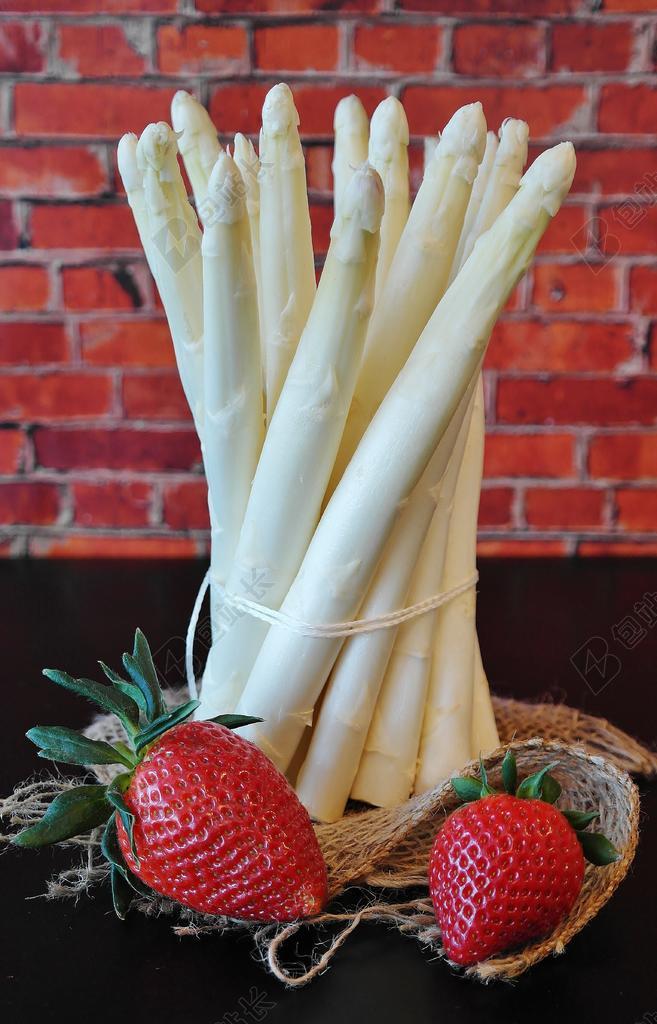 桌子上白色的芦笋和草莓背景图片
