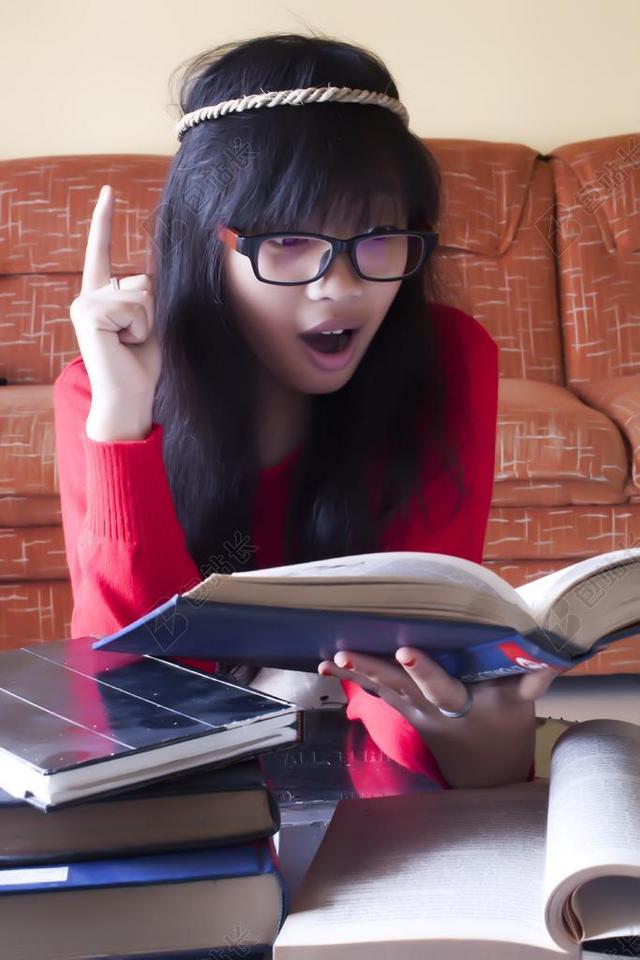 年轻红衣女孩手持书籍阅读背景图片