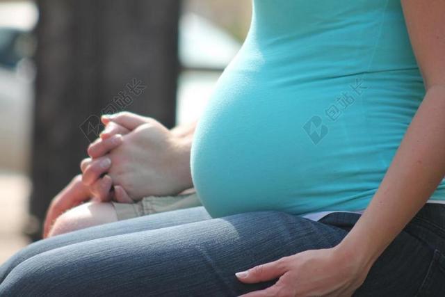 蓝衣牛仔裤孕妇大肚特写背景图片