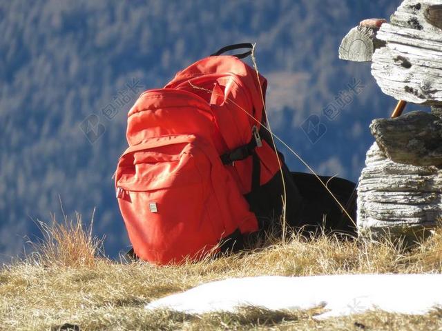 草地红色登山背包背景图片