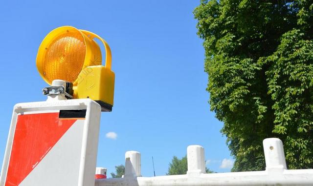 彩色交通经典蓝天下路面上的路障指示机器交通施工背景图片