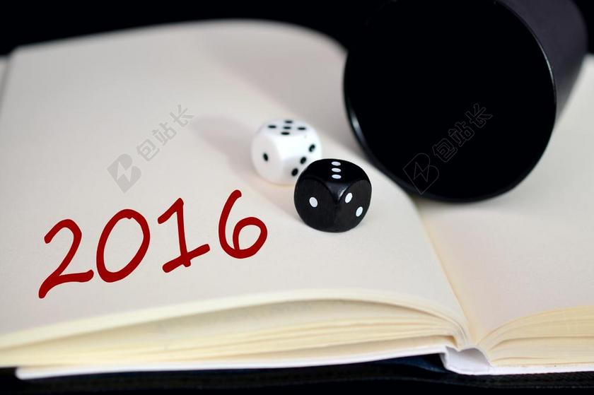 摄影寓意书本上的2016和黑白骰子年份符号骰子背景图片