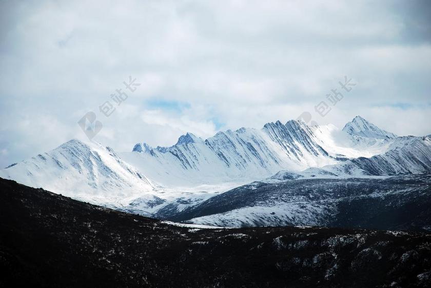 蓝黑自然鲜明白云下的雪山和群山自然山背景图片
