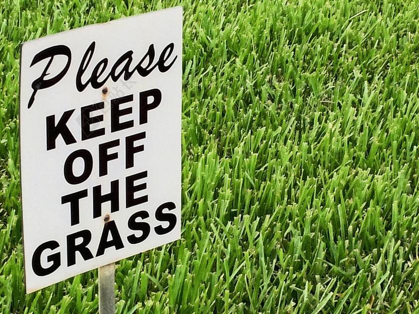 草地上白色的警告牌背景图片