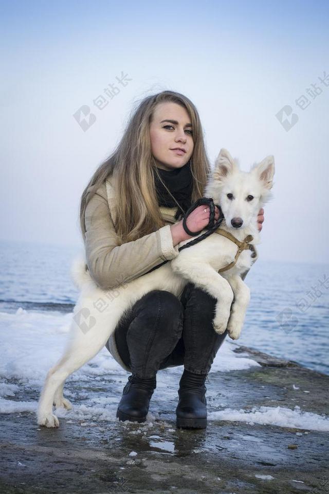 户外海边抱宠物狗拍摄长发女背景图片