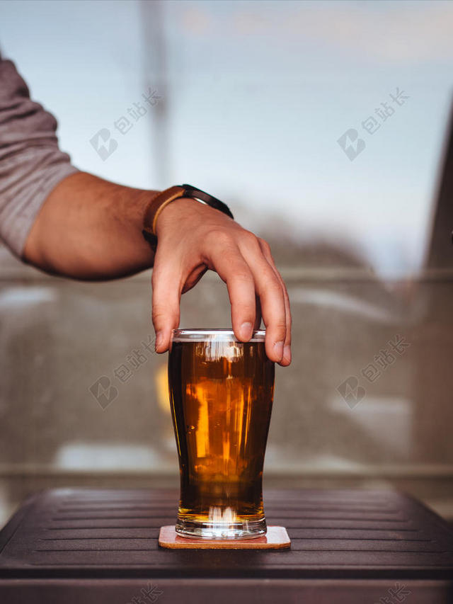 木桌上的棕色啤酒背景图片