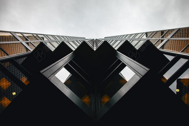 建筑创意仰视下的大楼几何弯曲墙面建筑设计背景图片