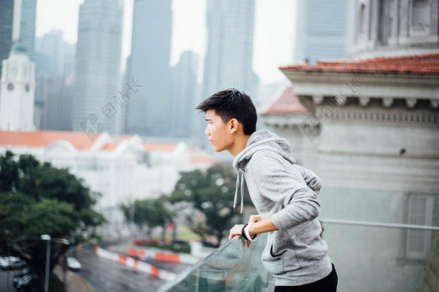 人物运动趴在玻璃栏杆上的男子观赏男士人物街拍背景图片