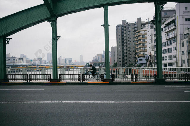 人钢铁大桥上骑车的男人背景图片