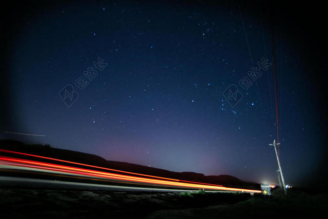 夜晚的星空和红色的光轨背景图片