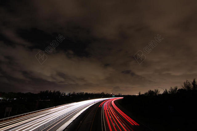 夜晚的红色和白色的道路灯轨背景图片