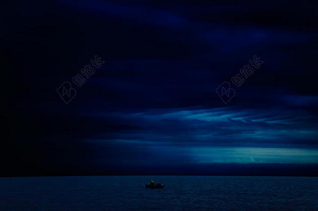 蓝色神秘黑夜下的海上船只夜晚大海中自然背景图片