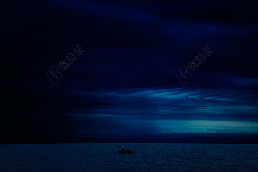 蓝色神秘黑夜下的海上船只夜晚大海中自然背景图片
