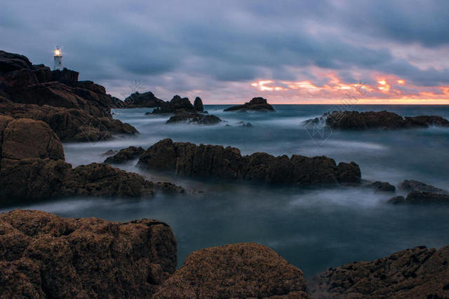 流动的潮水和礁石和灯塔背景图片