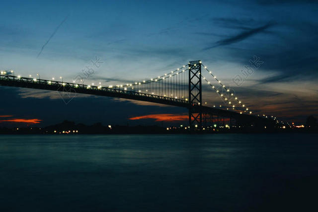 光影静谧夜幕下的霓虹大桥海面大海桥梁夜景光影背景图片