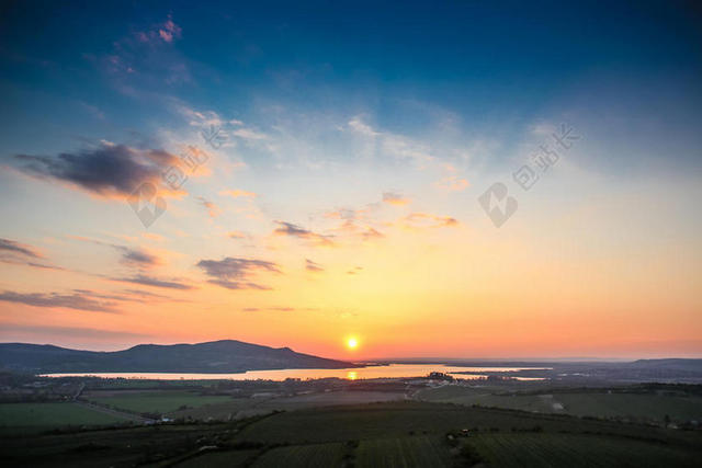 光影温暖蓝天下夕阳群山水自然光影落日背景图片