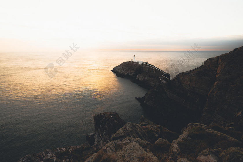 黑色礁石上白色的灯塔背景图片