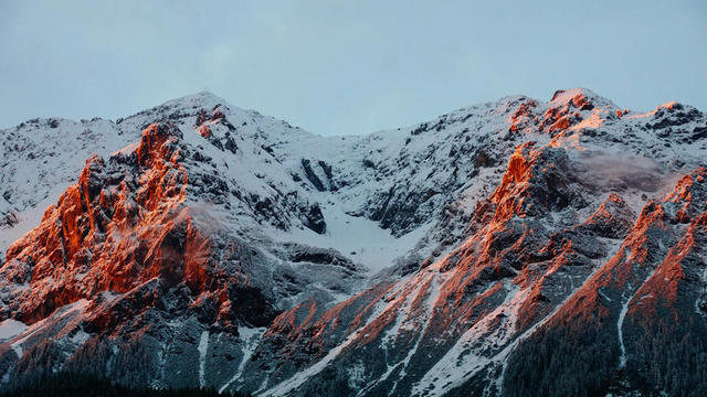 清晨的阳光和雪山山峰背景图片