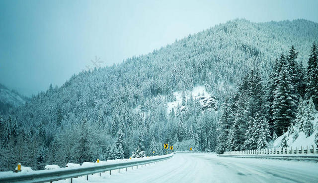 白色清新蓝天下的积雪上山林和公路道路山野背景图片