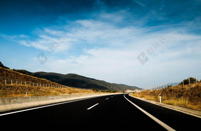 公路宽阔蓝天下的山野间的柏油路公路建设蓝天背景图片