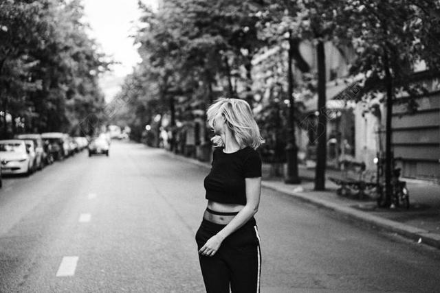 灰黑人物健美大街上回头的女孩运动健身公路街景背景图片