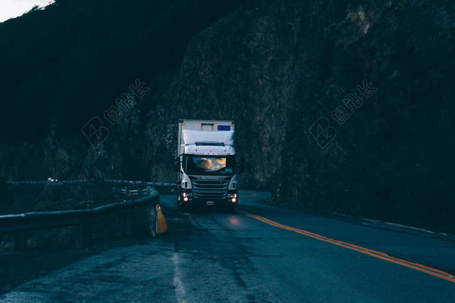 傍晚公路上的白色卡车背景图片
