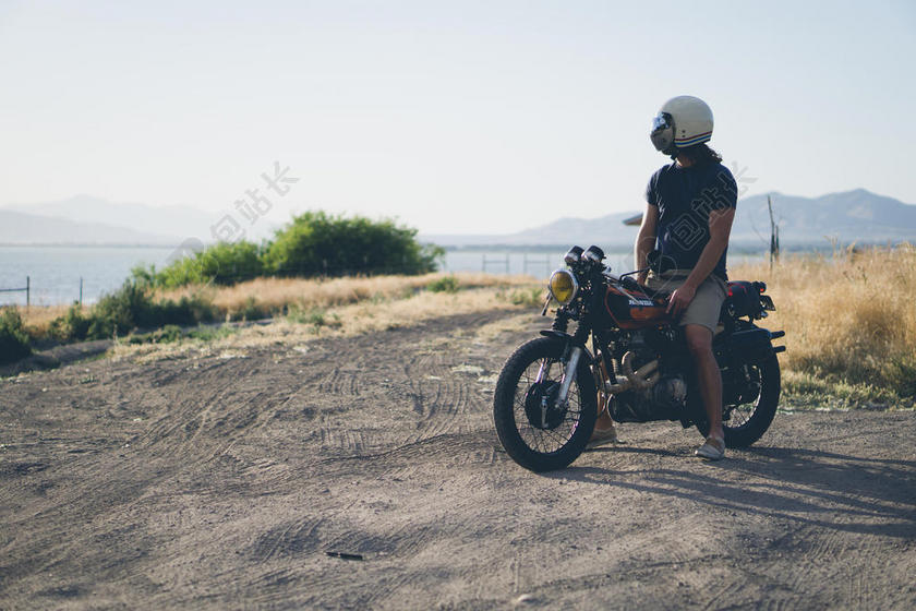 运动健美蓝天下山顶上的摩托车男子人物户外摄影运动背景图片