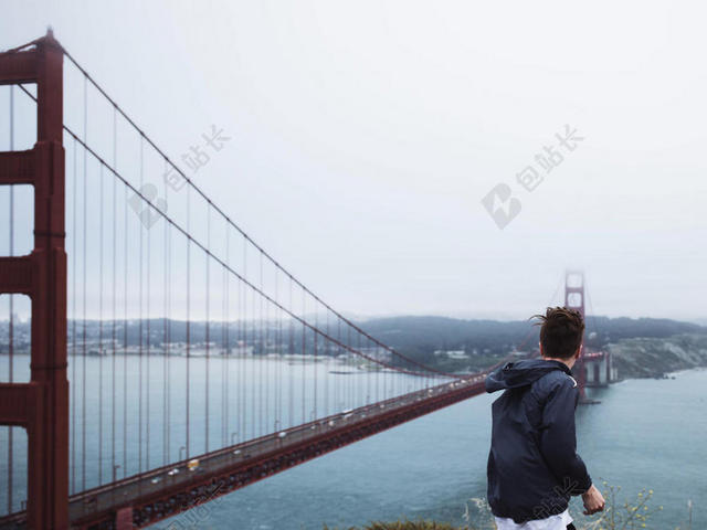 人物神秘山顶上观望大桥风景的男子背影人物户外交通背景图片