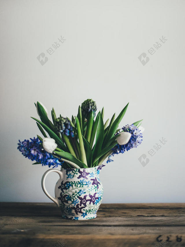 植物清新木桌上的杯子里面的叶子花朵鲜花植物装饰花束背景图片