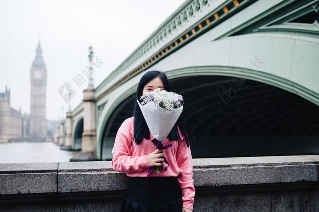 人物可爱栏杆边用花遮脸的女孩街拍植物人物背景图片