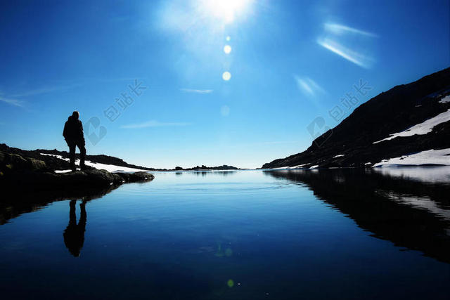 蓝黑自然炫彩阳光下的湖面和群山男子冒险远足自然背景图片