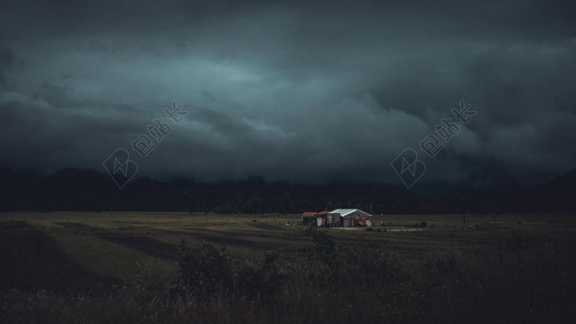 阴天田野上的小房子背景图片