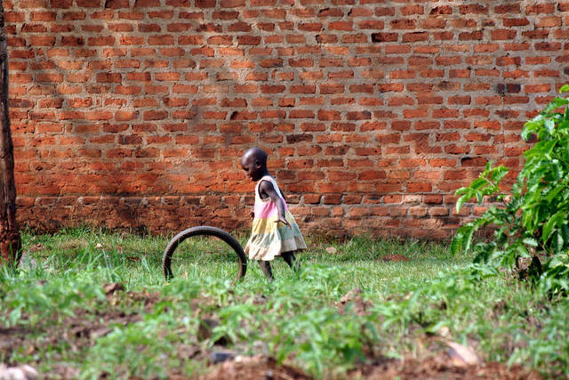 人物可爱墙边草地上玩耍的女孩儿童户外背景图片