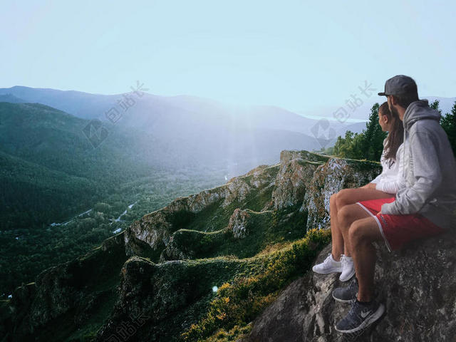 清晨的阳光和岩石上的青年背景图片