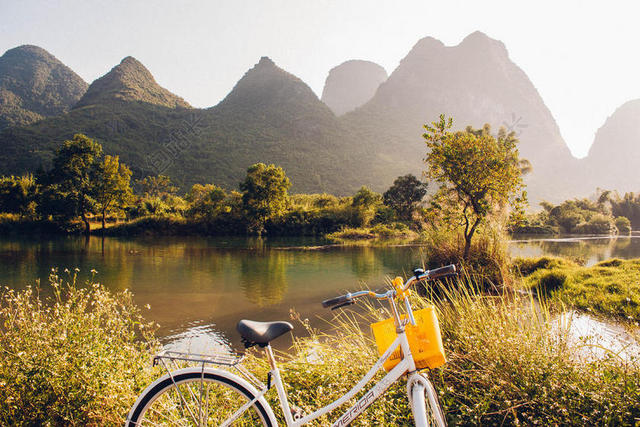 黄绿自然秀美连绵群山湖水和自行车自然山水骑行旅游背景图片