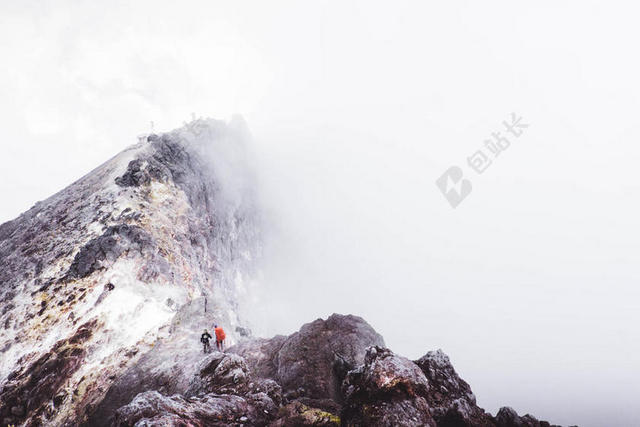 棕白自然壮美云雾下的山顶和人物自然旅游运动背景图片