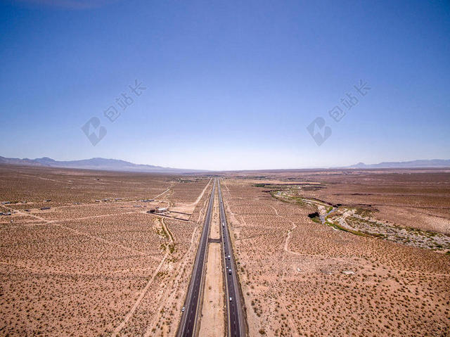 荒凉里黑色的笔直公路背景图片