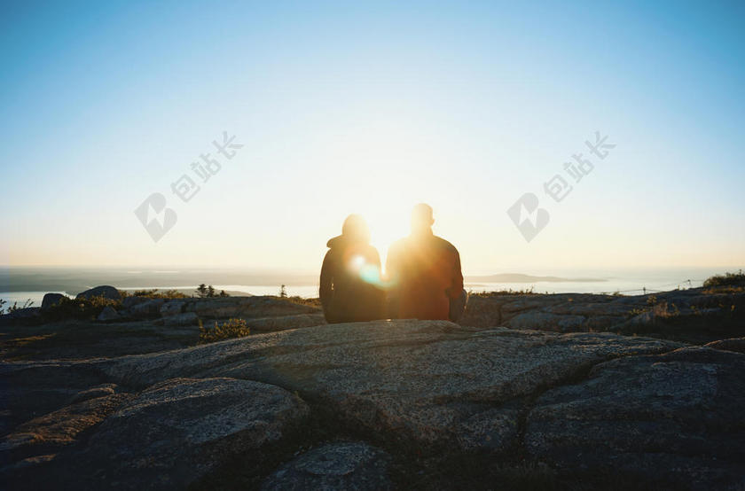 清晨的阳光和岩石上的情侣背景图片